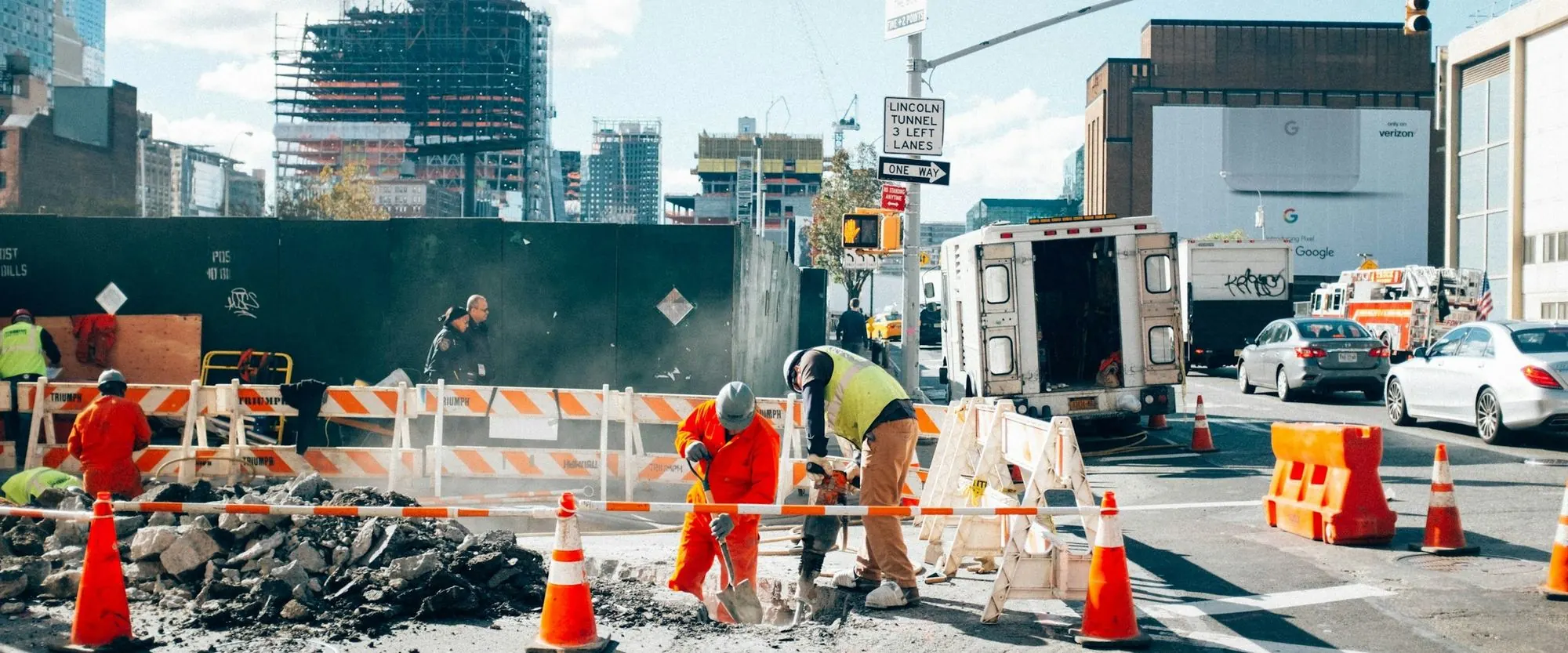A street crew working a road job below downtown towers