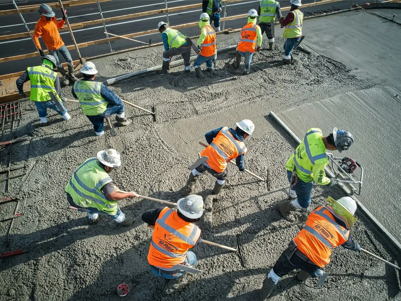 Aerial view of a crew raking and screeding a fresh concrete slab