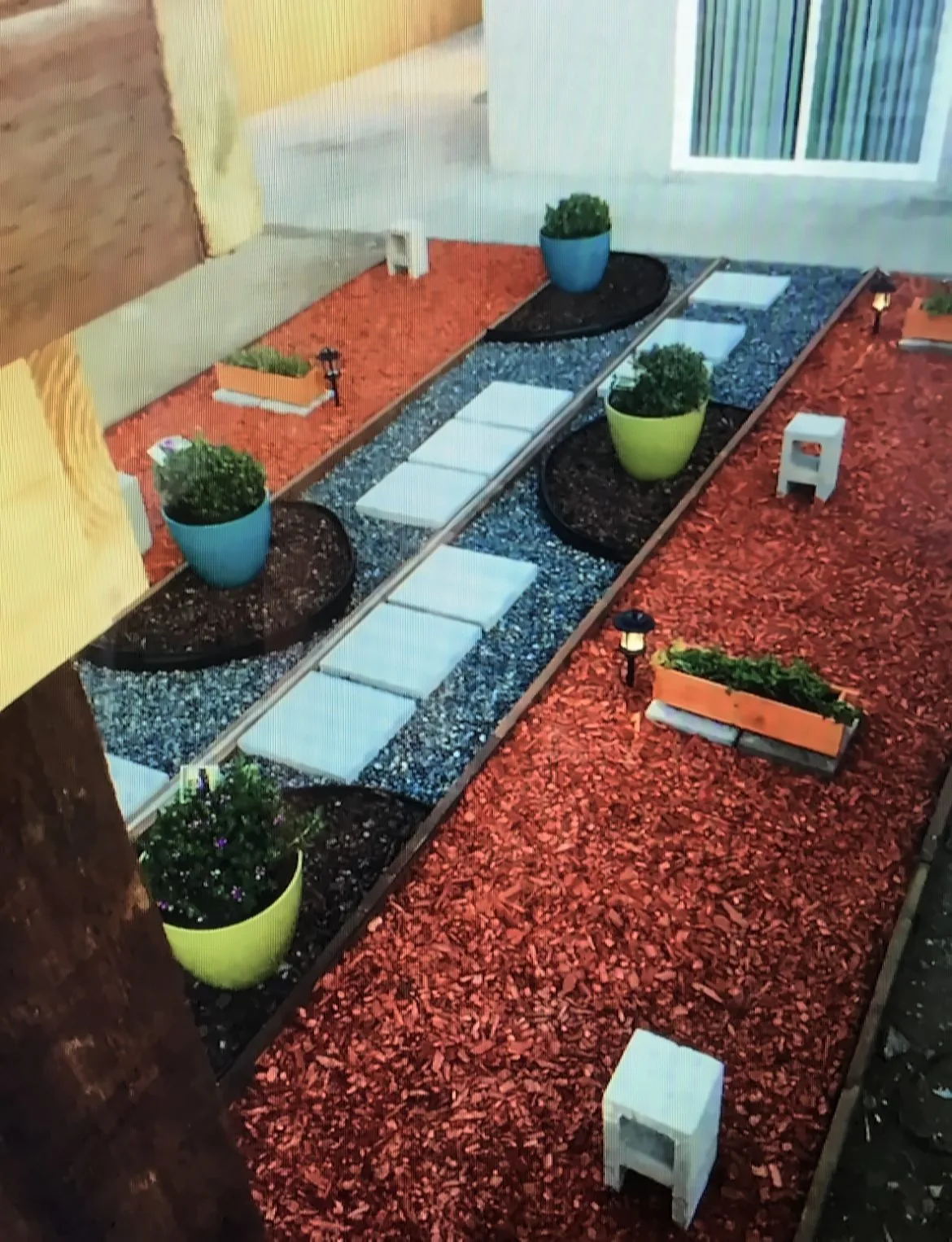 Side-yard garden path with pavers, river rock, red mulch beds and planters